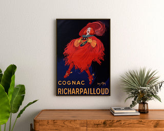 Vintage-Werbeplakat Cognac Richarpailloud, gerahmt über einer Holzkommode, zwischen Pflanzen.