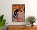 Werbeplakat Vintage Inoui-Tailleur, gerahmt über einer Holzkommode zwischen Pflanzen.