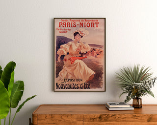 Werbeplakat Vintage Paris-Niort, Sommerneuheiten, gerahmt über einer Holzkommode zwischen Pflanzen.