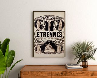 Vintage-Werbeplakat Verdun, Statuetten und Neujahrsgeschenke, gerahmt über einer Holzkommode zwischen Pflanzen.