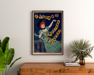Vintage-Reiseplakat – Livorno, Badesaison, gerahmt über einer Holzkommode, umgeben von Pflanzen.