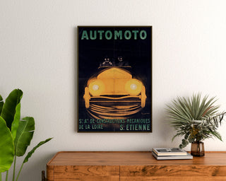 Vintage-Poster Automoto, Saint-Étienne, gerahmt über einer Holzkommode zwischen Pflanzen.
