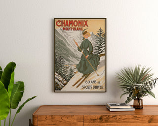 Vintage-Poster Chamonix, 60 Jahre Wintersport, gerahmt über einer Holzkommode zwischen Zimmerpflanzen.