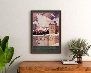 Vintage-Poster Font-Romeu, Wintersport, gerahmt über einer hölzernen Kommode, zwischen Pflanzen.