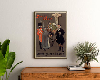 Vintage-Plakat Shamus O’Brien, Opera Comique, gerahmt über einer Holzkommode, zwischen Pflanzen.